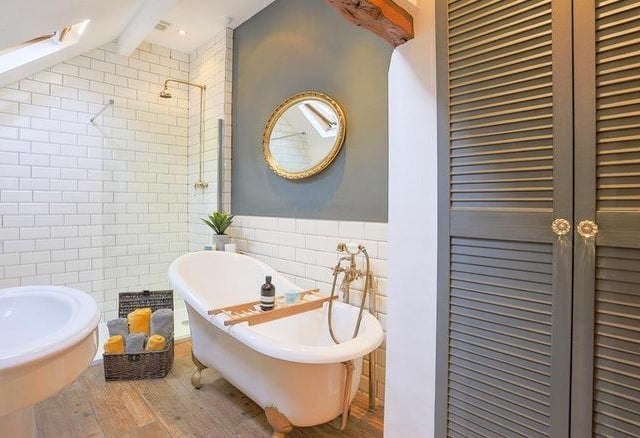 The luxury bathroom includes a roll top bath, traditional style wash basin, high level wc