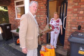 Coun Robert Oates presents a bouquet to Brunhilda Brock on being the 100th shopping delivery of the pandemic service. EMN-200626-145905001