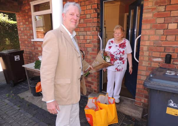 Coun Robert Oates presents a bouquet to Brunhilda Brock on being the 100th shopping delivery of the pandemic service. EMN-200626-145905001