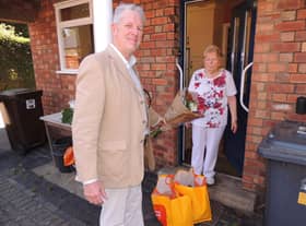 Coun Robert Oates presents a bouquet to Brunhilda Brock on being the 100th shopping delivery of the pandemic service. EMN-200626-145905001