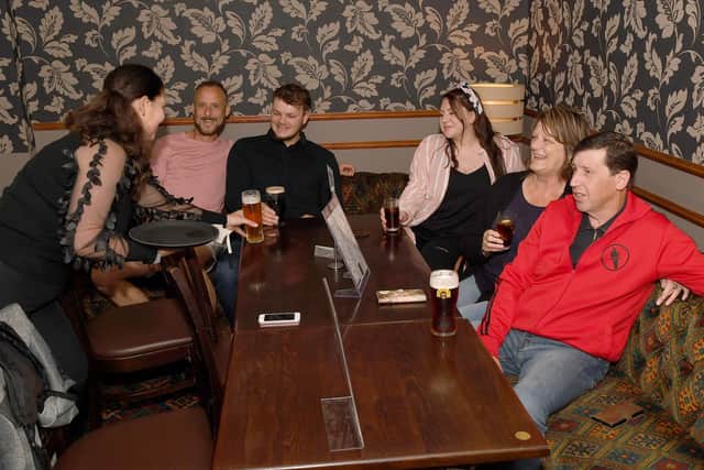 Landlady of the Welcome Inn in Skegness Clare Chrysostomou serving Jason Klimczuk, Joshua Branton, Remi Martin, Stephanie Klimczuk and Kevin Elliott.