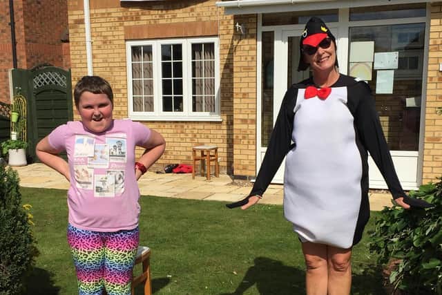 Lisa dressed as a penguin with student Christopher Bellion, aged 10