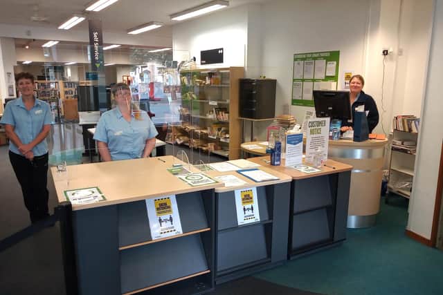 New normal - Sleaford Library staff behind their screens for the takeaway service. EMN-200720-120133001