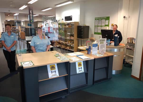 New normal - Sleaford Library staff behind their screens for the takeaway service. EMN-200720-120133001