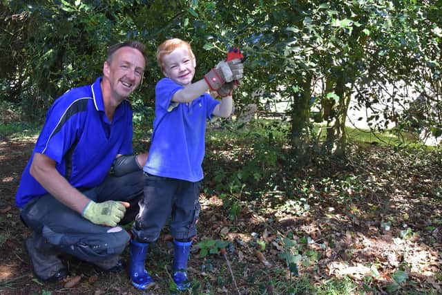 Five-year-old Alexander Lunn busy pruning with his dad Jonathan. Picture John Edwards