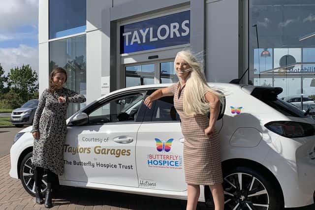 Handing over the car with a socially distanced elbow bump ... Megan from Taylors Motor Group and Bridget from the Butterfly Hospice Trust.