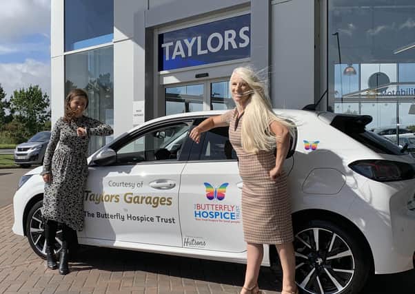Handing over the car with a socially distanced elbow bump ... Megan from Taylors Motor Group and Bridget from the Butterfly Hospice Trust.