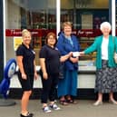 Jacqui Dales, owner of the London Road Bakery, presents the funds to SoLDAS trustees Judith Warnes and Veronica Robinson, watched by members of staff.