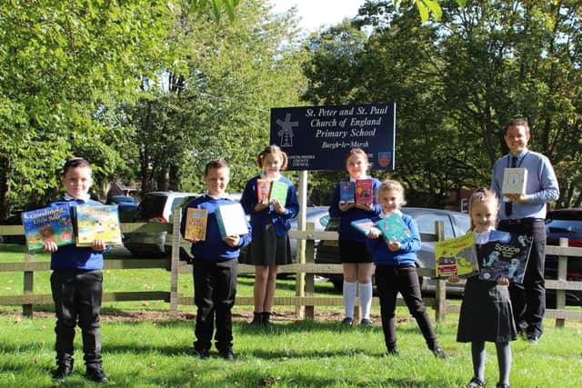 Pupils of St Peter and St Paul's school in Burgh-le-Marsh with their books and   Deputy Head Mr Anderson.