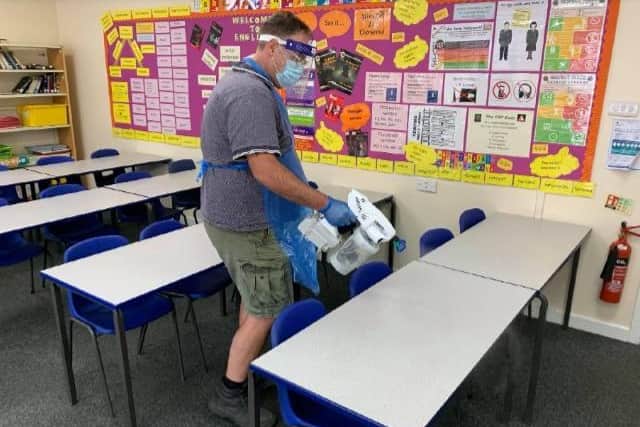 Site manager, Mr Bishell, sanitising student desks during break time following use by students in year group ‘bubbles’ during the morning.