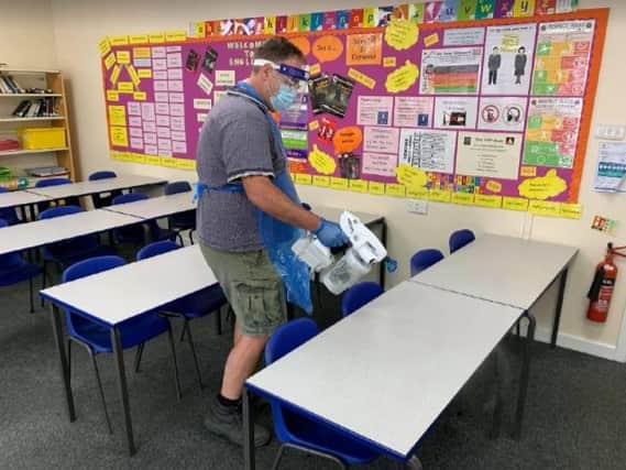 Site manager, Mr Bishell, sanitising student desks during break time following use by students in year group ‘bubbles’ during the morning.