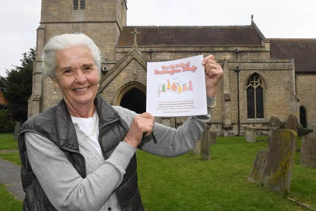 Ruskington church being taken away for repair. Di Cross with a book written by local school children. EMN-200921-170134001