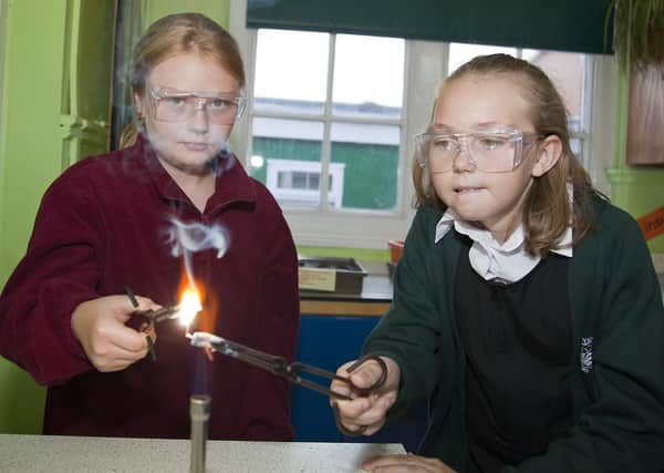 Pictured are Anouska Dobbin, left, and Melissa Sills conducting scientific experiments on burning metal.