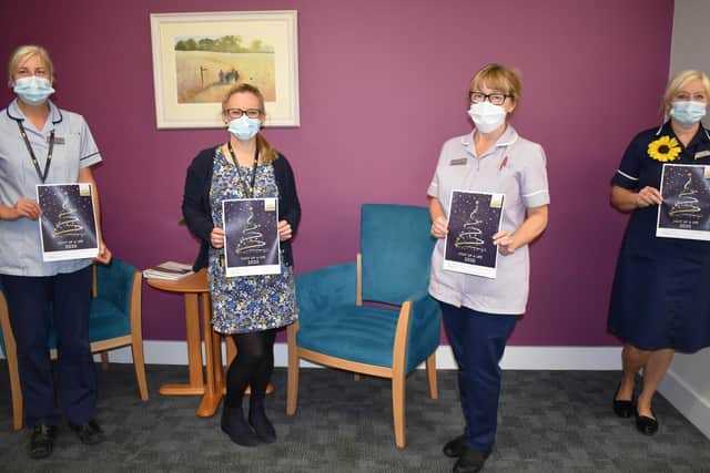Hospice staff are pictured with this year’s Light up a Life booklet