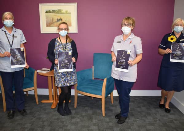 Hospice staff are pictured with this year’s Light up a Life booklet