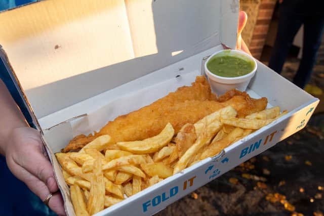 A portion of the delicious fish and chips with a side of mushy peas.