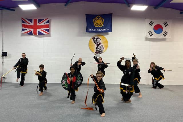 Black belts posing with with a variety of weapons used in Kuk Sool Won.