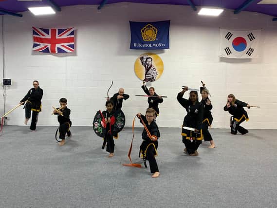 Black belts posing with with a variety of weapons used in Kuk Sool Won.