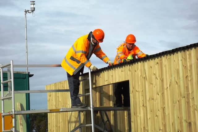 Andy Stevens (left) and Andy Evans fixing the roof on the new station building.