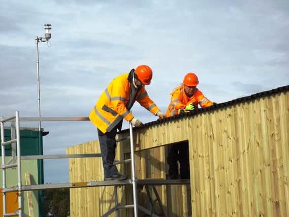 Andy Stevens (left) and Andy Evans fixing the roof on the new station building.