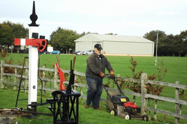 Chris Latham cutting the grass past the newly installed ground frame for inter-locking the points and signal (which controls entry to the run round loop at Walls Lane station.