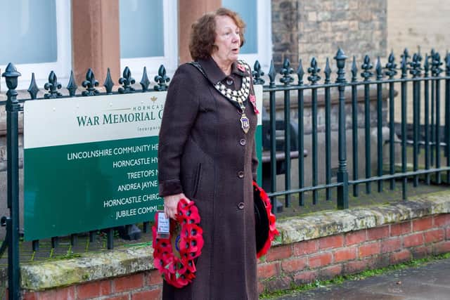 Mayor Councillor Fiona Martin prepares to place two wreaths