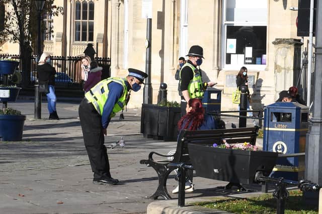 Officers chat to a woman on a bench in the town centre