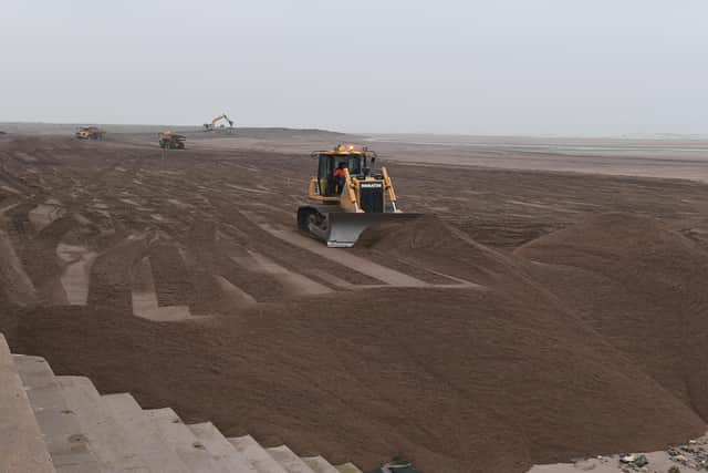 Environment Agency workers moving said on the beach at Winthorpe.