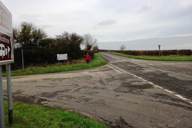 Janet Stubbs with her homemade road sign - warning motorists about the 'dangerous' junction.