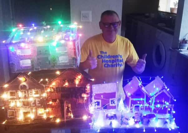 Patrick Carlin, pictured with some of his themed wooden houses.