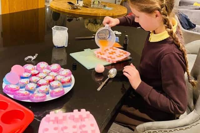 Belle making soap for her sale.