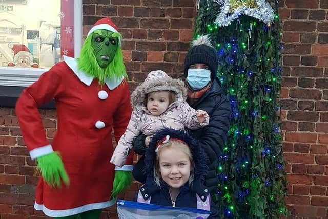 The Grinch -otherwise known as Miss Drury, Class 1 teacher, and pupll Louisa, 5, hand over cards to Kayleigh Pinnner at Pilgrim