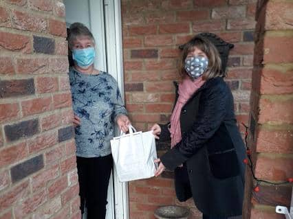 Pamela Lambe receives her Christmas surprise from Age UK Lindsey Befriending Administration Assistant Kathryn Pollard.