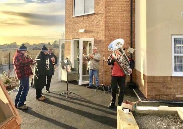 Raising spirits with an alfresco performance at Avocet House Care Home, members of Swineshead Silver Band.