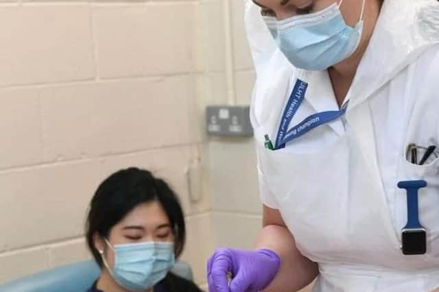 Rachel Carritt, lead nurse for siren study and covid vaccinator, prepares the first dose in Lincolnshire of the new Oxford vaccine for junior doctor Mi Joo Choi of the Pilgrim Hospital ICU.