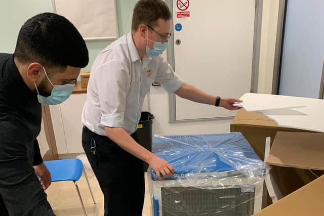 Boots staff unpacking a fridge to store the Covid-19 vaccines. EMN-211001-115925001