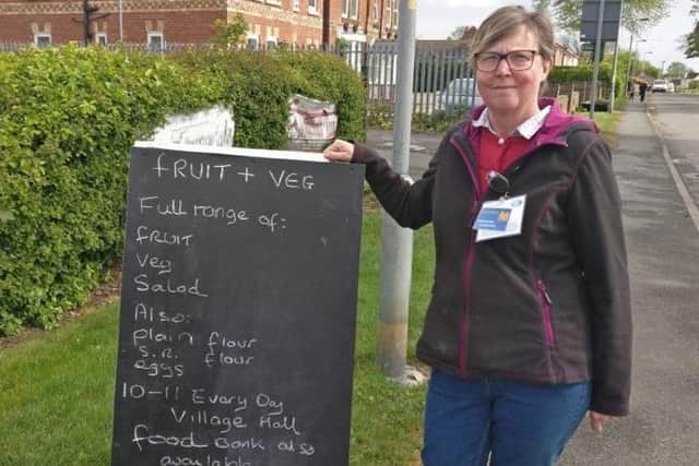 The sign advertising the fruit and veg store outside the village hall.