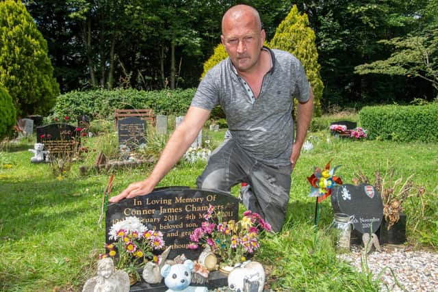 Heartbroken Darren Chambers at the grave of his son Conner, pictured last summer after the first incident.