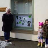 WI member Marian Rippin, left, with granddaughter Sarah Delgado and great-granddaughters Isabella (5) and Emelia (3). Sarah designed the poster. Sitting girl blowing dandelion hearts; each contains a wish the children spoke about with the family.  A photo of the poster was also displayed to their fellow class mates at Ravendale Primary School for them to find out more about the subject.