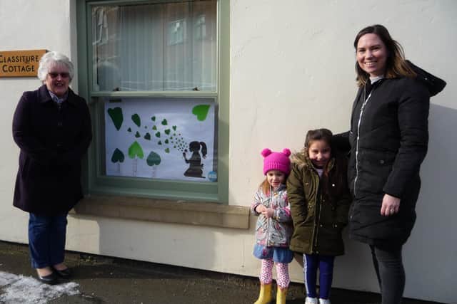 WI member Marian Rippin, left, with granddaughter Sarah Delgado and great-granddaughters Isabella (5) and Emelia (3). Sarah designed the poster. Sitting girl blowing dandelion hearts; each contains a wish the children spoke about with the family. A photo of the poster was also displayed to their fellow class mates at Ravendale Primary School for them to find out more about the subject.