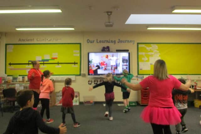 Key worker children in school follow Mr Motivator's moves. EMN-210103-104137001