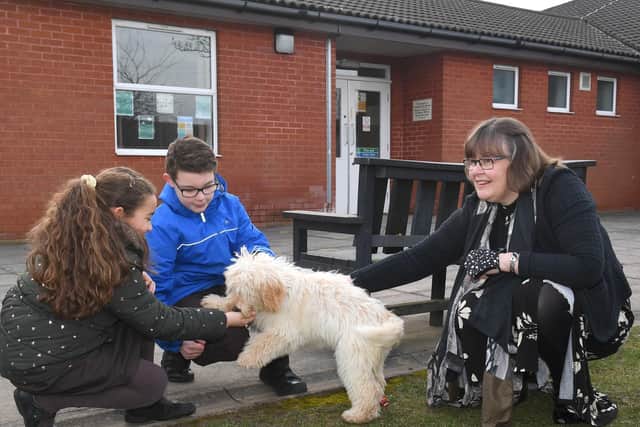 So pleased to see you! Head teacher Mrs Caroline Wellsted with the new school therapy dog, welcoming pupils Amaiya Facey 8 and Torin Facey 11
