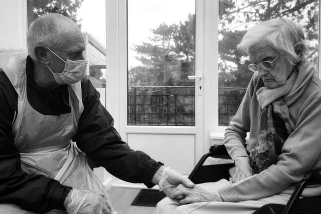 An emotional moment at Syne Hills Residential Home in Skegness as John Epton hold the hand of his 101-year-old mum, Mary Clarke.