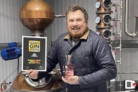 On top of the world: Tristan Jørgensen with his award winning gin - and the certificate to prove it