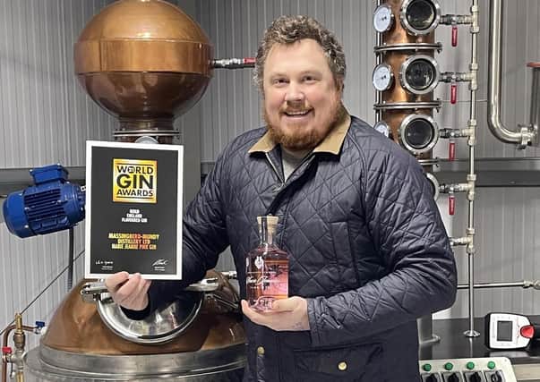 On top of the world: Tristan Jørgensen with his award winning gin - and the certificate to prove it