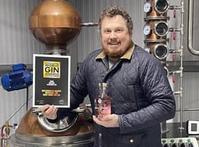 On top of the world: Tristan Jørgensen with his award winning gin - and the certificate to prove it