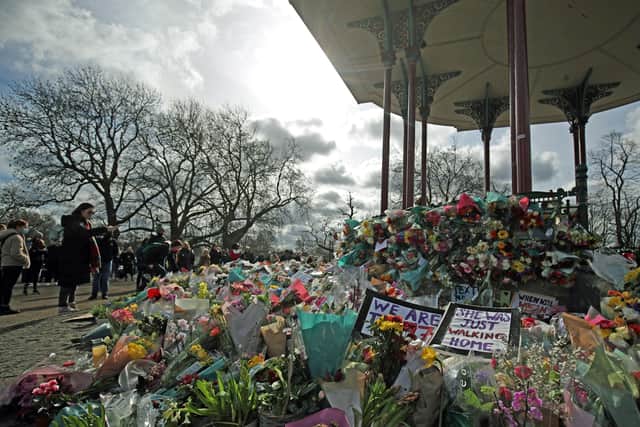 People view floral tributes left at the band stand in Clapham Common, London, after clashes between police and crowds who gathered on Clapham Common on Saturday night to remember Sarah Everard. Serving police constable Wayne Couzens, 48, appeared in court on Saturday charged with kidnapping and murdering the 33-year-old marketing executive, who went missing while walking home from a friend's flat in south London on March 3. Photo: PA EMN-210317-093631001
