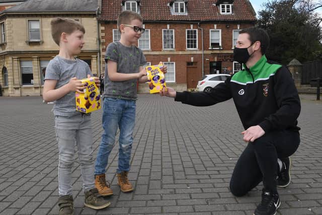 Casa17 and Sleaford Town U15s giving away Easter Eggs in Sleaford Market Place. Glenn Long with Alfie Stone 5 and Joey Stone 8. EMN-210504-094248001