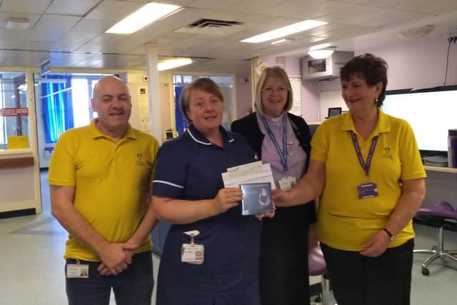 Elaine presenting a cheque to Ward Sister Rachel Pickering with Reverend Barbara Hutchinson and Volunteer Nigel Brasier.