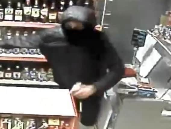 The robber with his face covered is caught on CCTV
